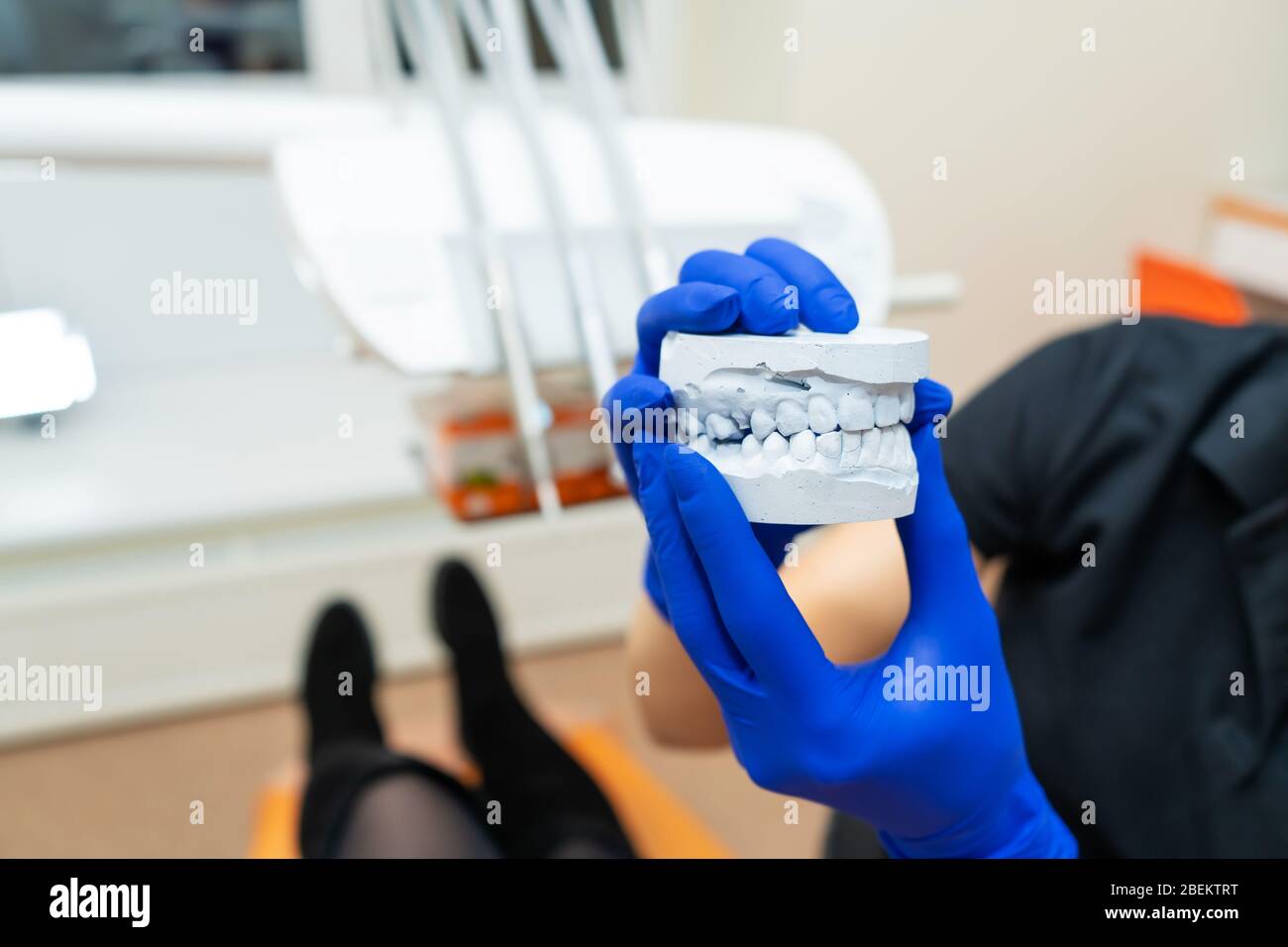 Beautiful girl professional doctor dentist orthodontist shows a plaster