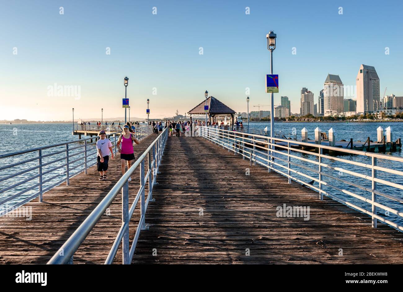 Coronado Ferry Landing in the afternoon. Passengers wait for the ferry that will carry them to San Diego. The San Diego skyline is on the right. Stock Photo