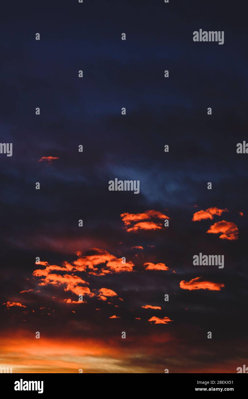 Sunset with the orange clouds under dark sky Stock Photo - Alamy