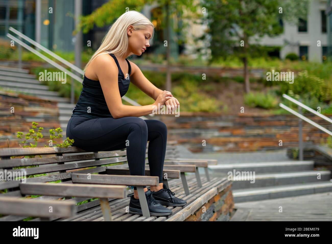 Fit woman setting up fitness smart watch device before running Stock Photo