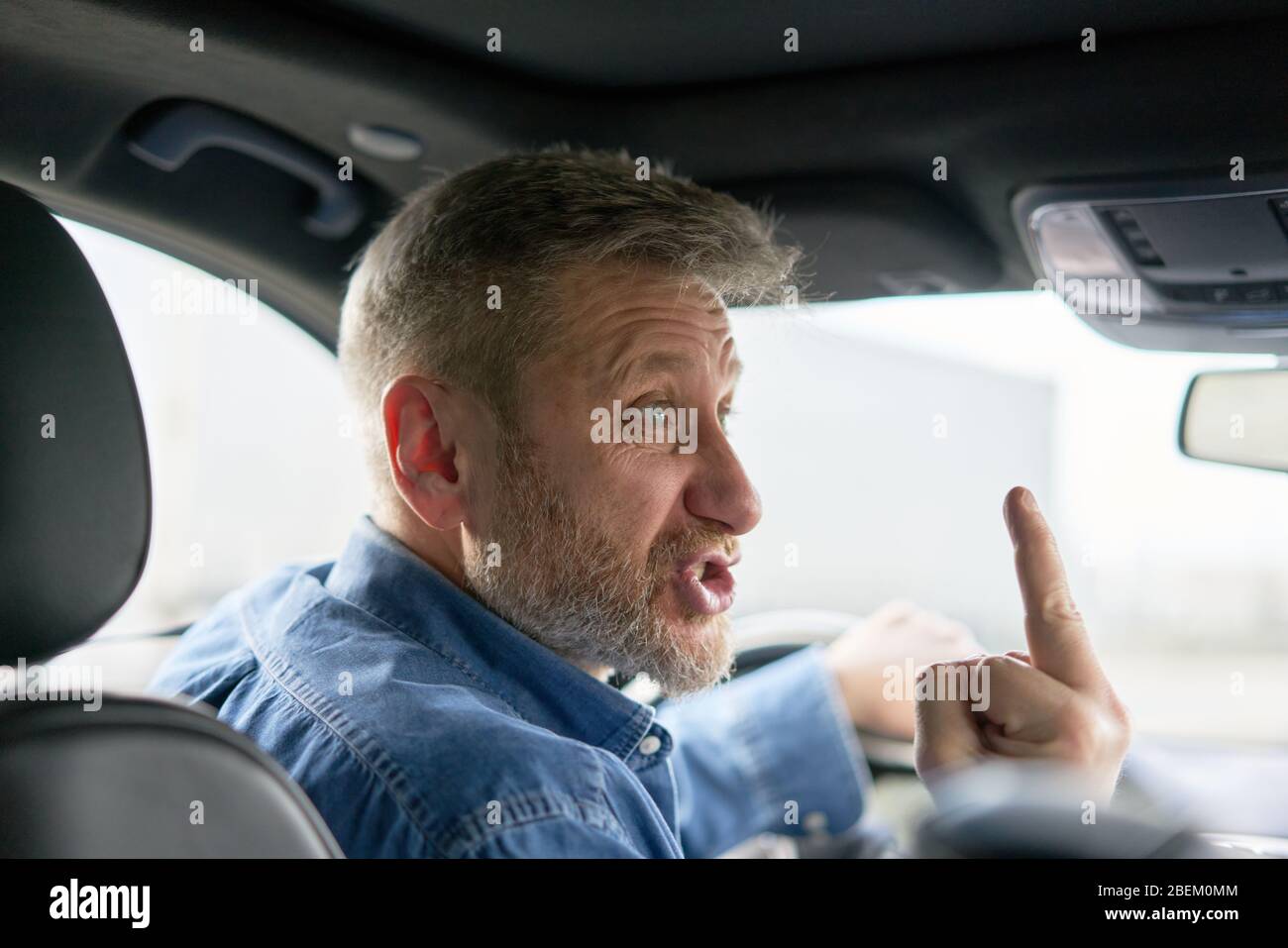 unfriendly aggressive car driver showing the middle finger Stock Photo