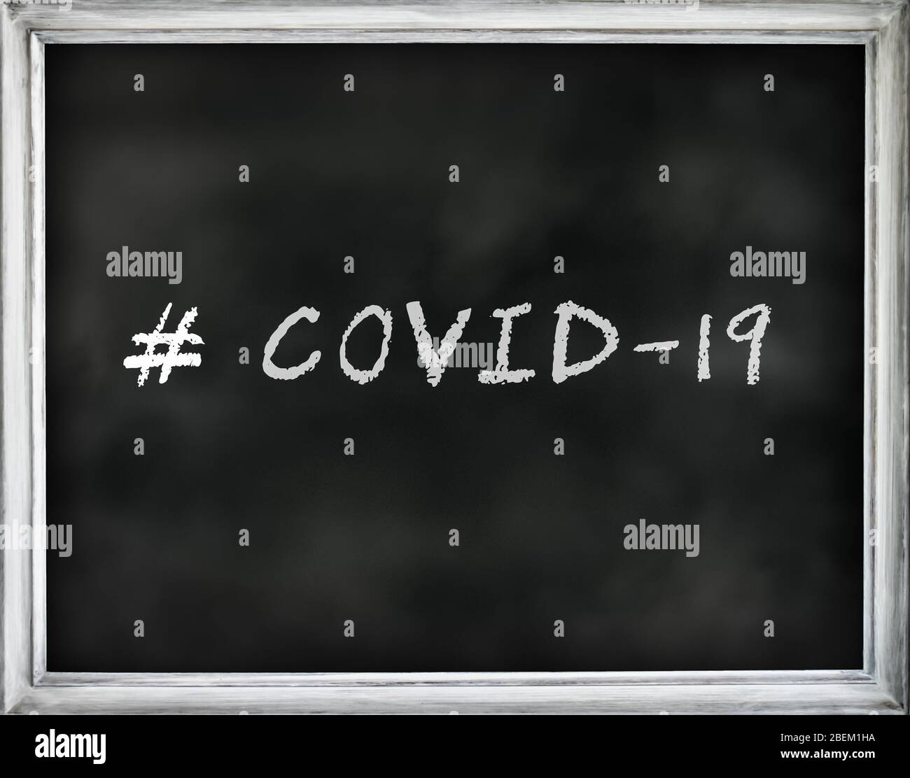 # COVID-19 written text on black chalkboard with white frame. Stock Photo