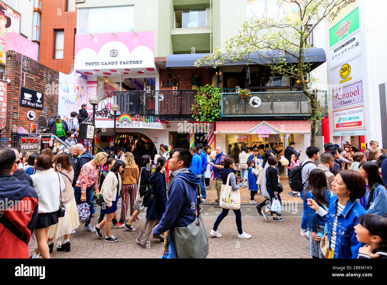 Harajuku, Tokyo. Takeshita street, crowds walking pass the Rainbow Sweets Harajuku store and Totti Candy Factory, famous for its giant cotton candy. Stock Photo