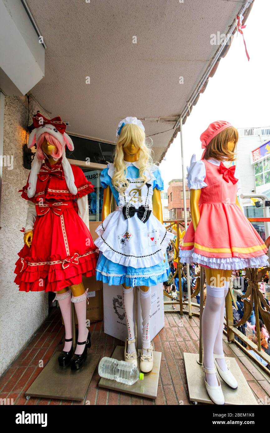 Three colourful Japanese Lolita style maid costumes including an alice in wonderland, on mannikins at a store in Takeshita Street, Harajuku, Tokyo. Stock Photo