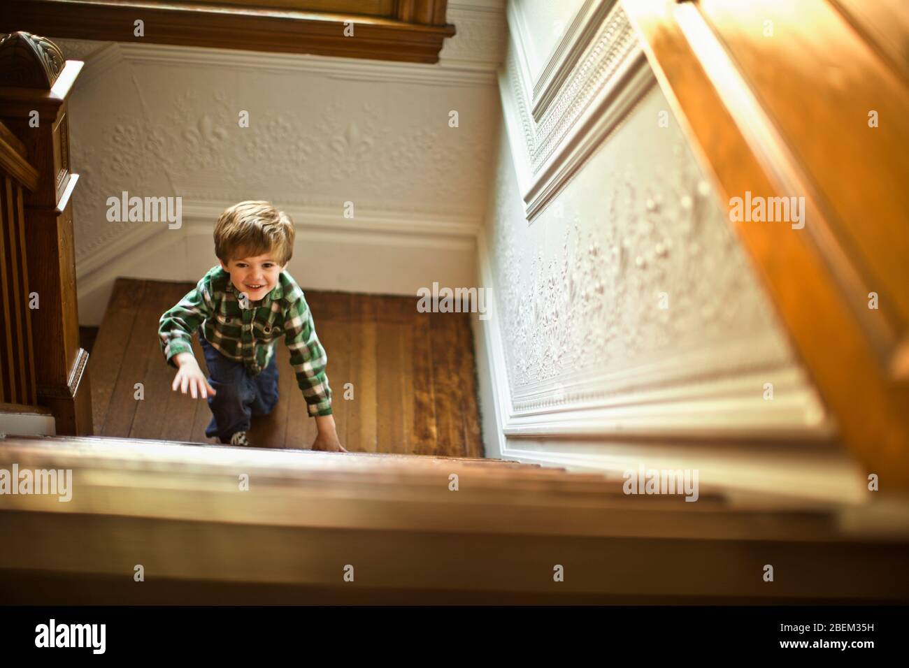 Young boy climbing up a staircase Stock Photo