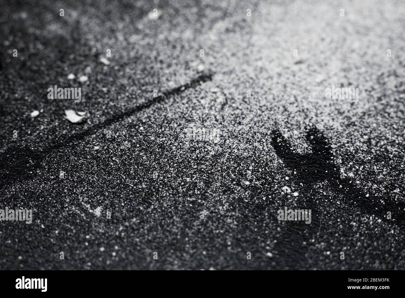Traces of tools on a black table dusted with white dust Stock Photo - Alamy