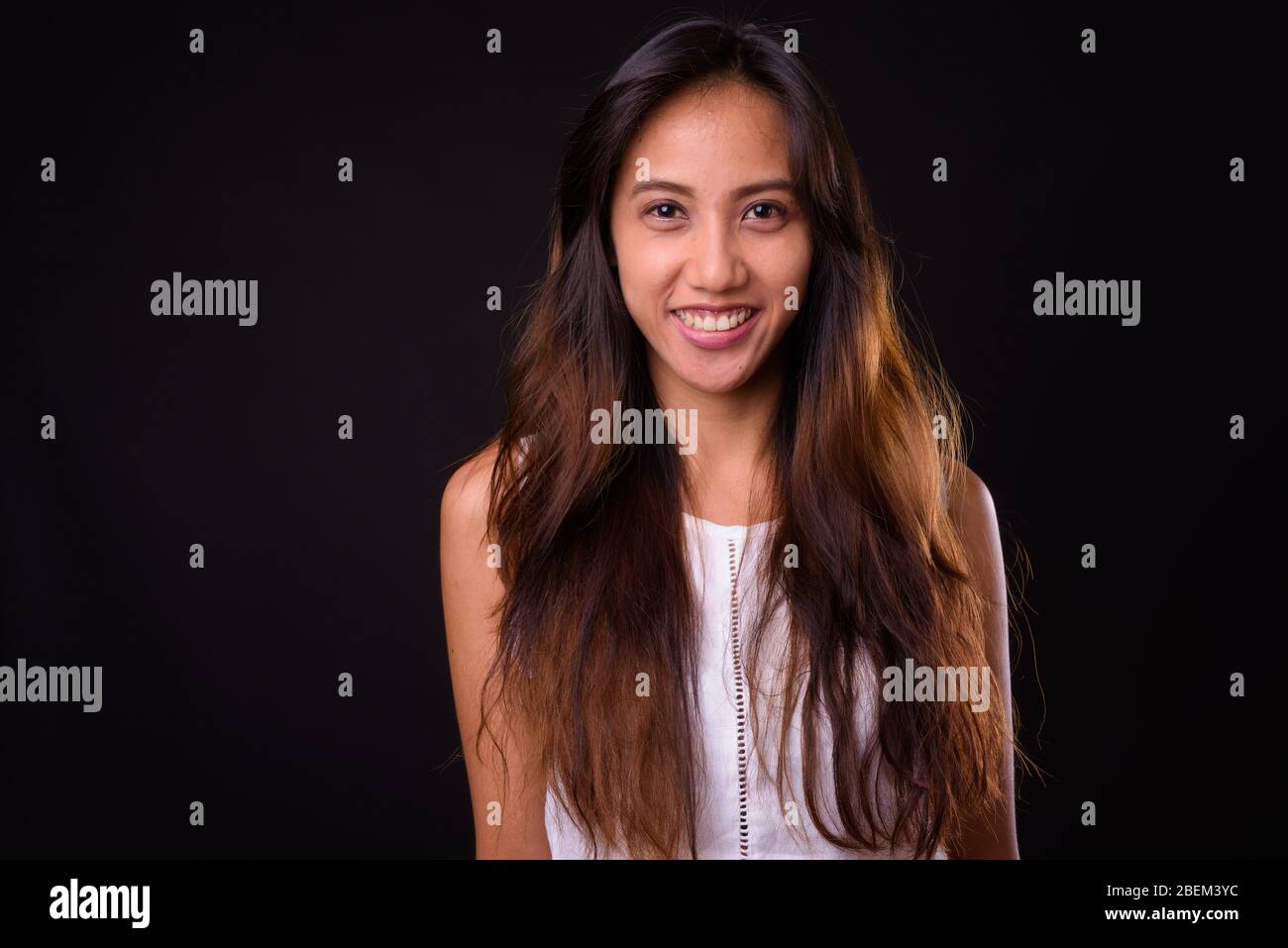 Young beautiful Asian woman against black background Stock Photo
