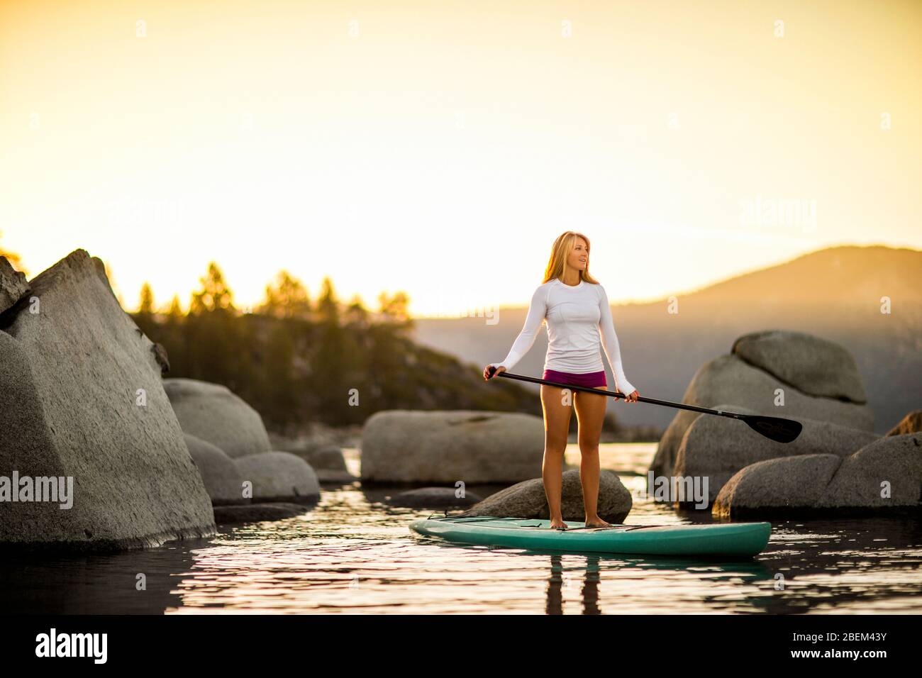 Young woman paddle boarding on a lake Stock Photo