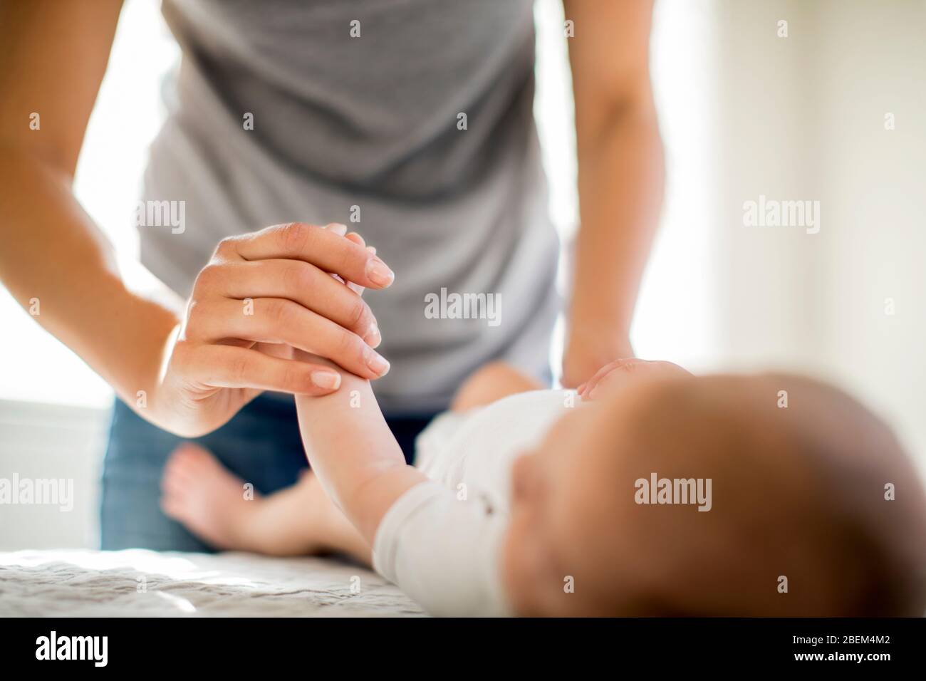 Mid adult mother holding her baby's hand Stock Photo
