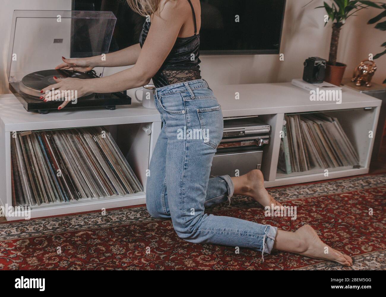 Young woman putting a vinyl record on. Stock Photo