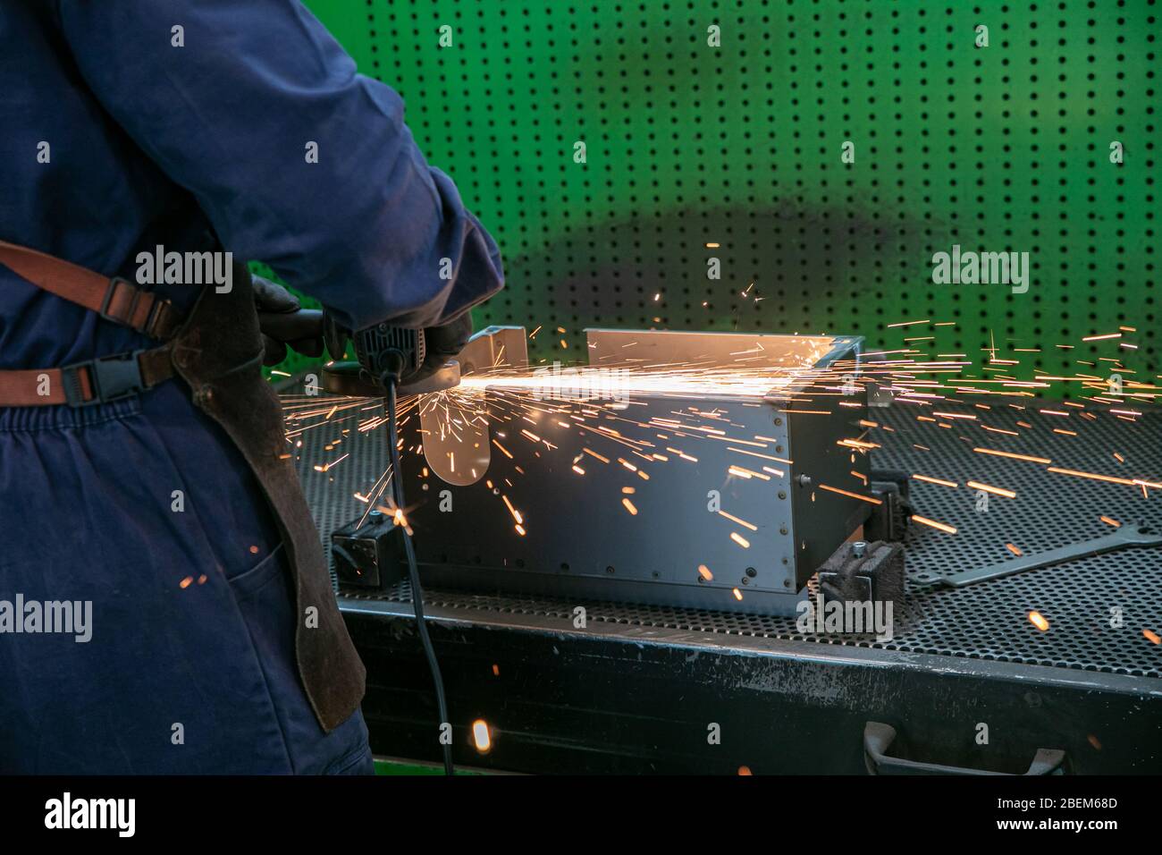 industrial worker cutting, grinding and polishing metal surface