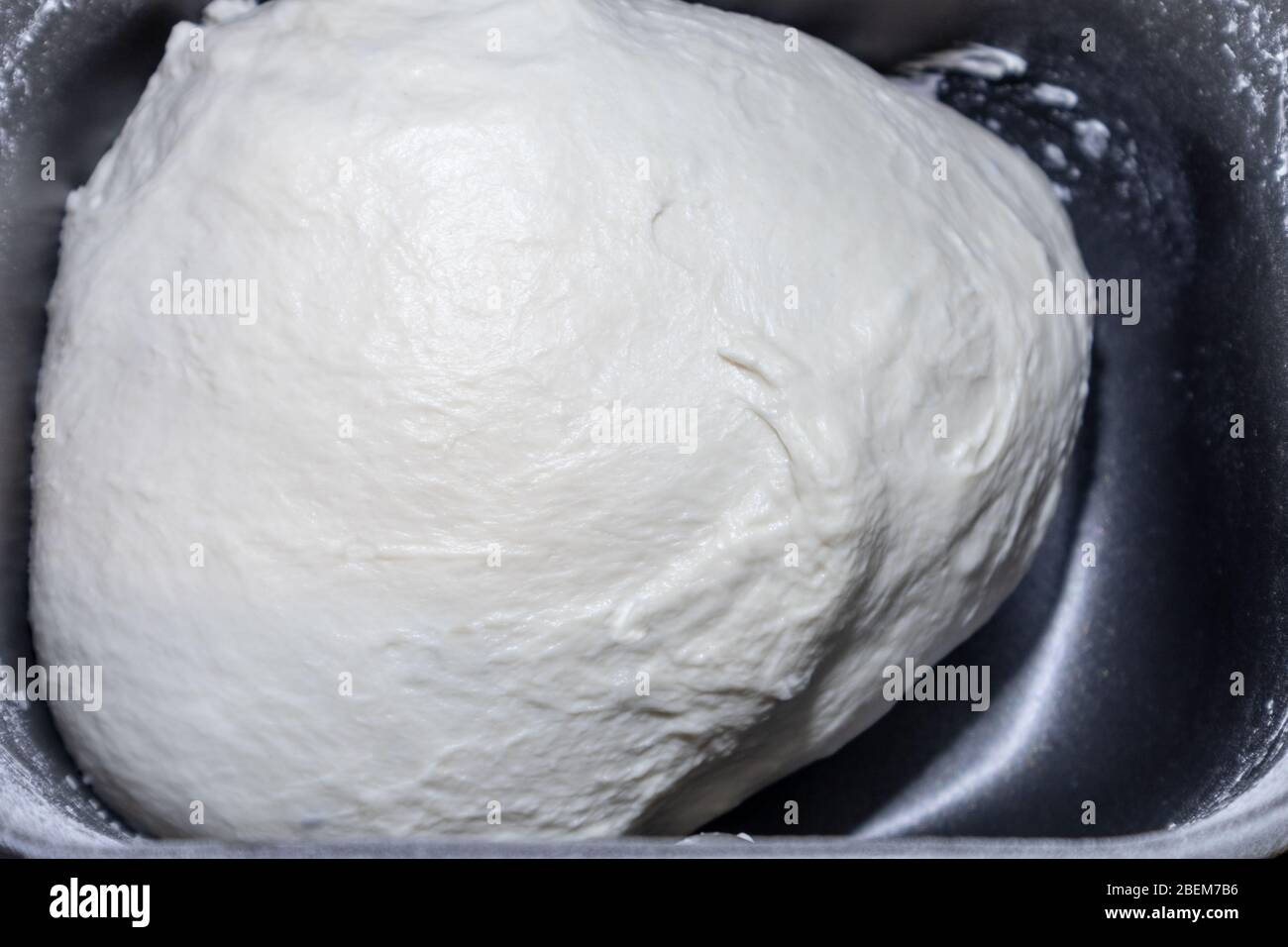 Bread dough in breadmaker machine dispenser. Just mixed ready to rise fresh white home made bread pizza pastry duff cooking process close-up Stock Photo