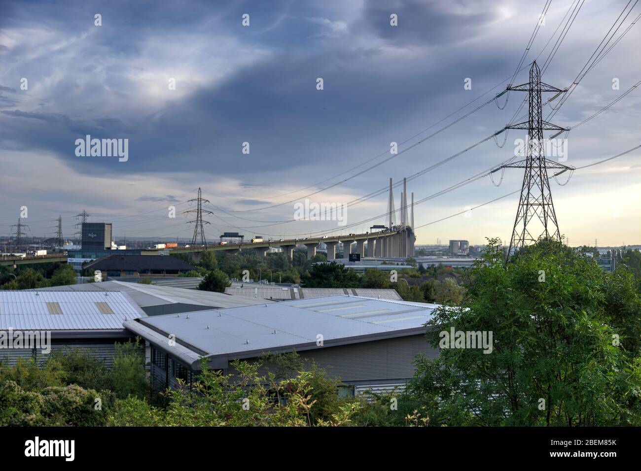 Dartford, United Kingdom - August 30, 2019: Industrial units and electricity pylons with Dartford Bridge over River Thames in background Stock Photo