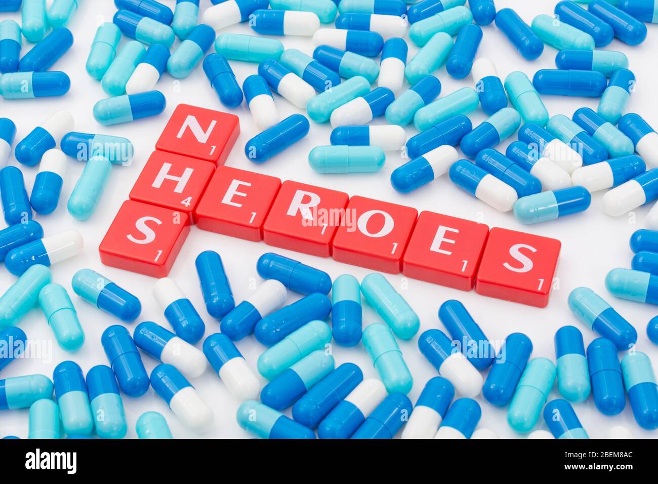 NHS Heroes letters tiles & assorted blue pills. For NHS in Covid 19 pandemic, NHS staff, NHS prescriptions, UK National Health Service, medicine in UK Stock Photo
