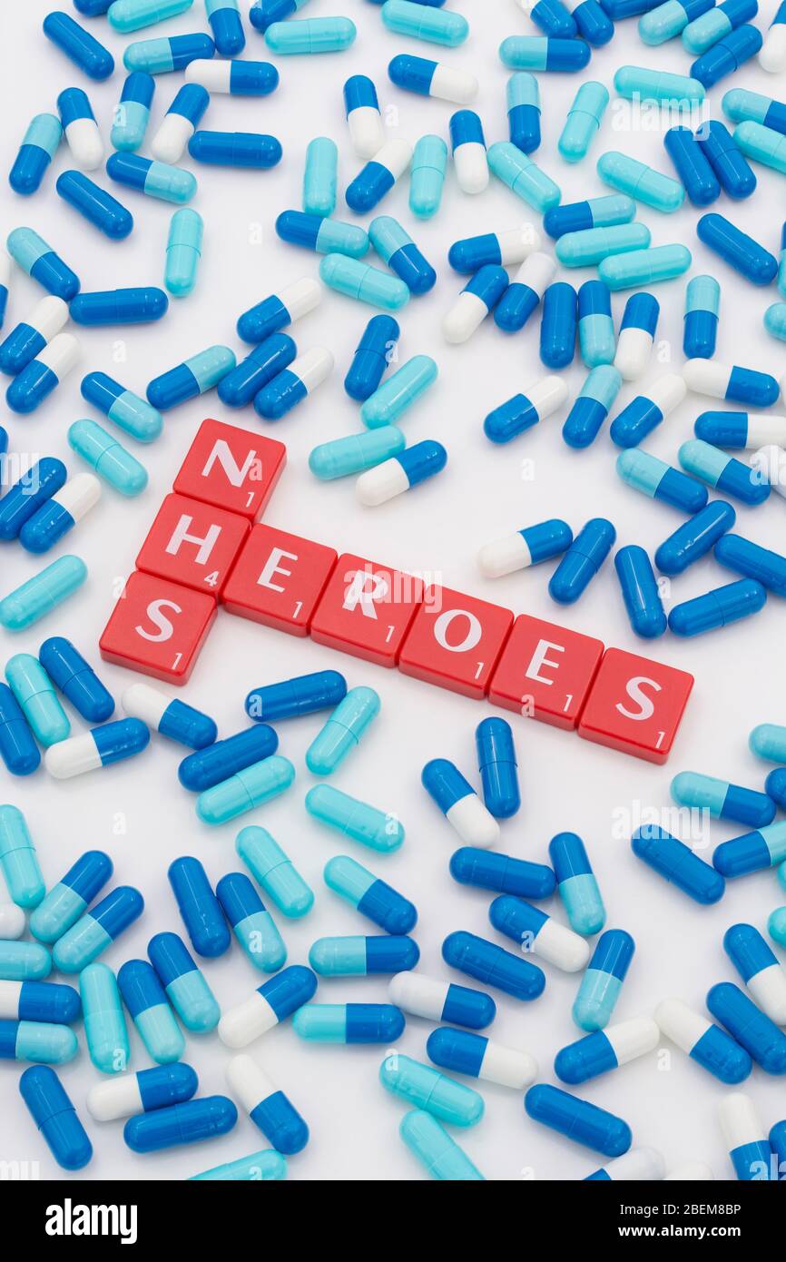 NHS Heroes letters tiles & assorted blue pills. For NHS in Covid 19 pandemic, NHS staff, NHS prescriptions, UK National Health Service, medicine in UK Stock Photo