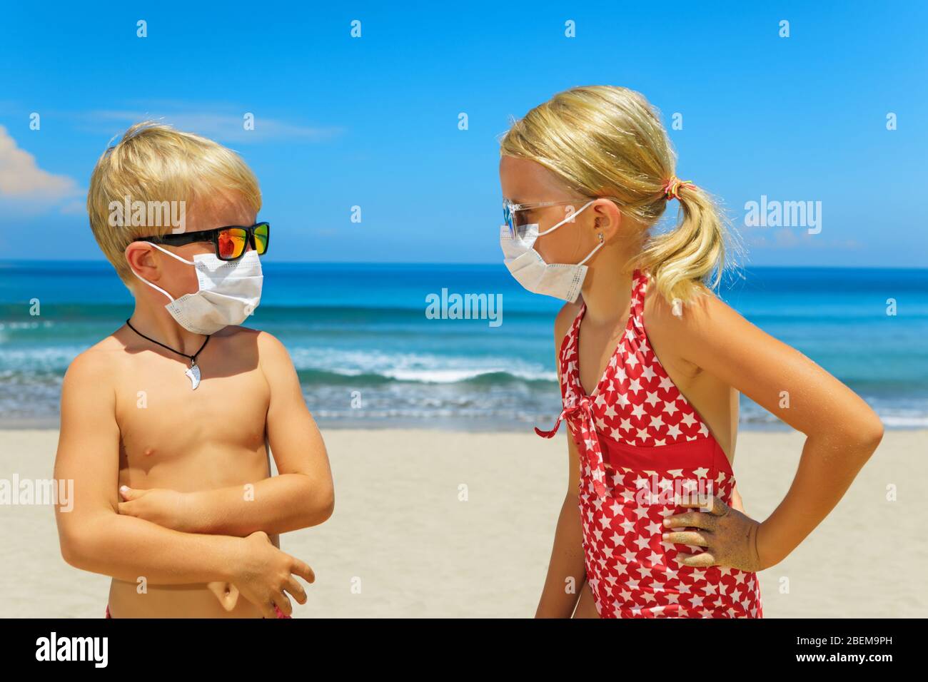 Two young funny children wearing sunglasses, protective mask on sea beach. Summer tours, cruise cancellation due to coronavirus COVID-19 world epidemic Stock Photo