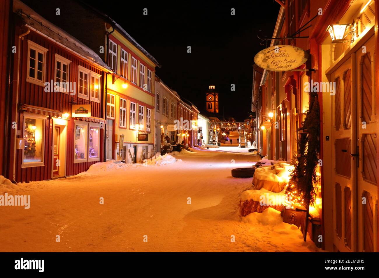 Cosy evening mood in the Kjerkgata by night in the historical mining town of Røros in wintertime, Norway Stock Photo