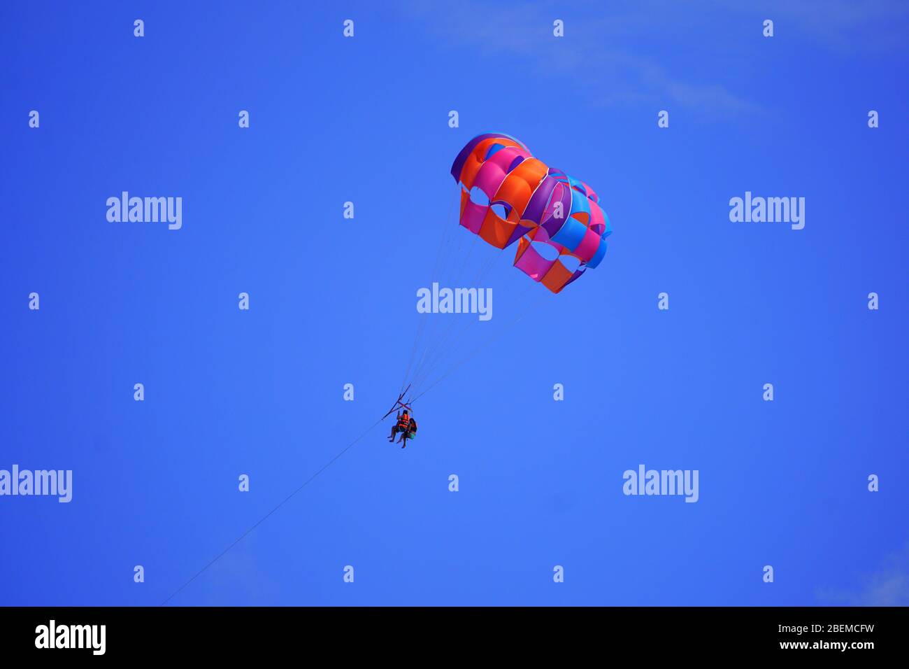 People up in the blue sky, parasailing Stock Photo