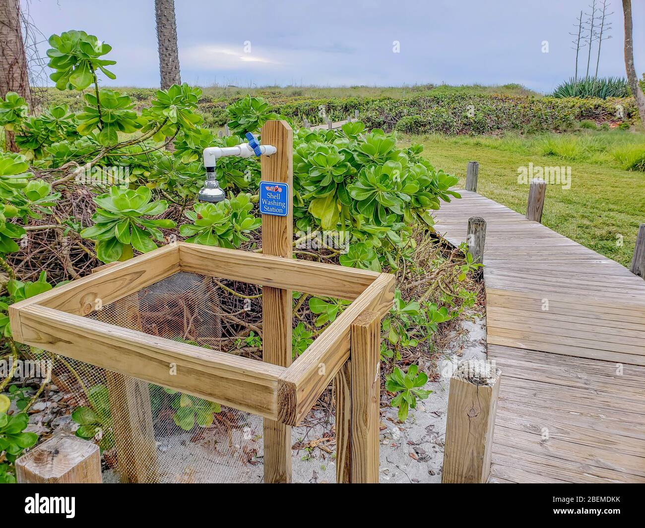 Shell washing station for tourists to rinse shells beside wooden beach path or boardwalk to beach on Captival Island. Shelling is a vacation activity. Stock Photo