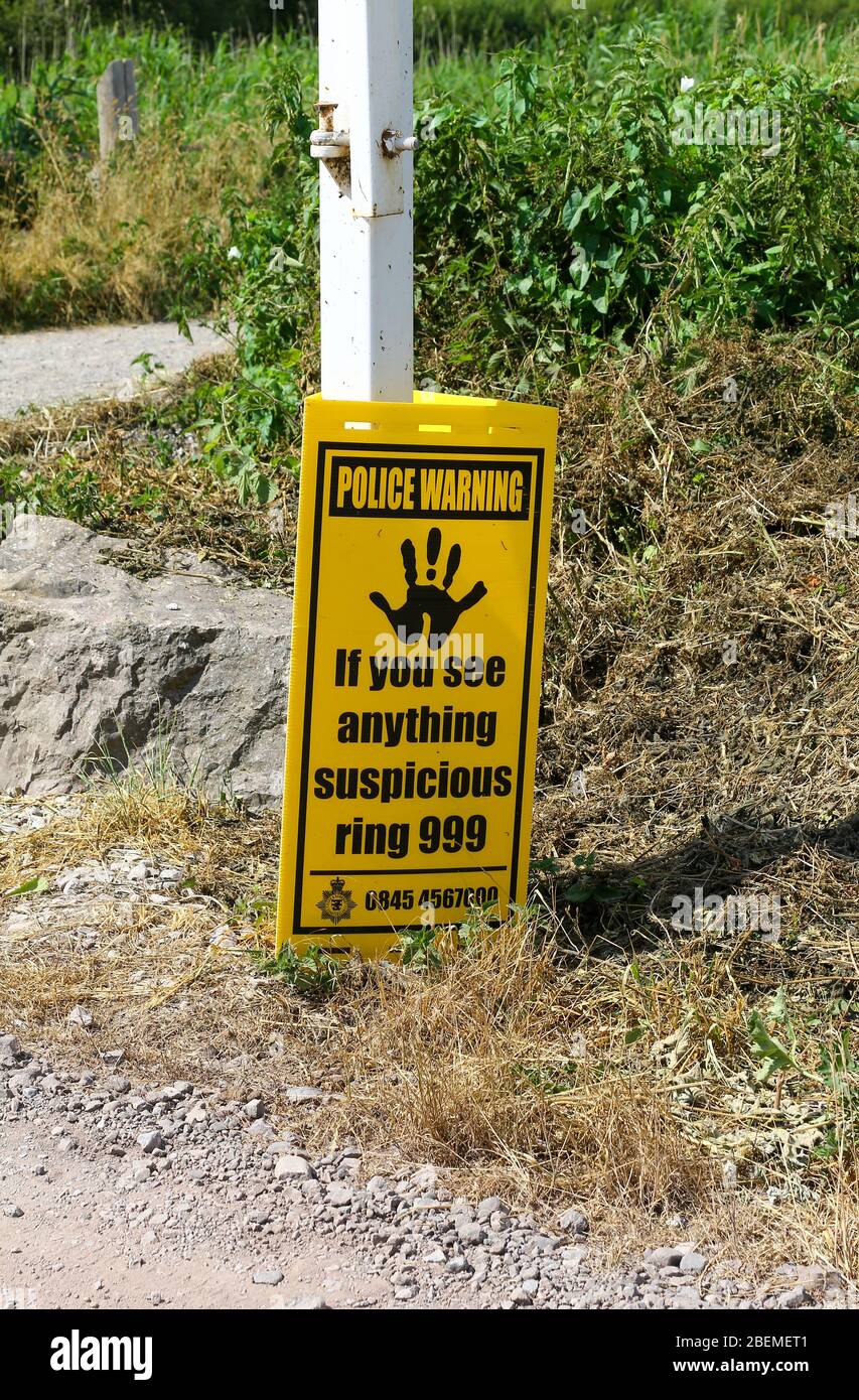 A sign saying 'police warning If you see anything suspicious ring 999' at Westhay Moor Nature Reserve, Somerset, England, UK Stock Photo