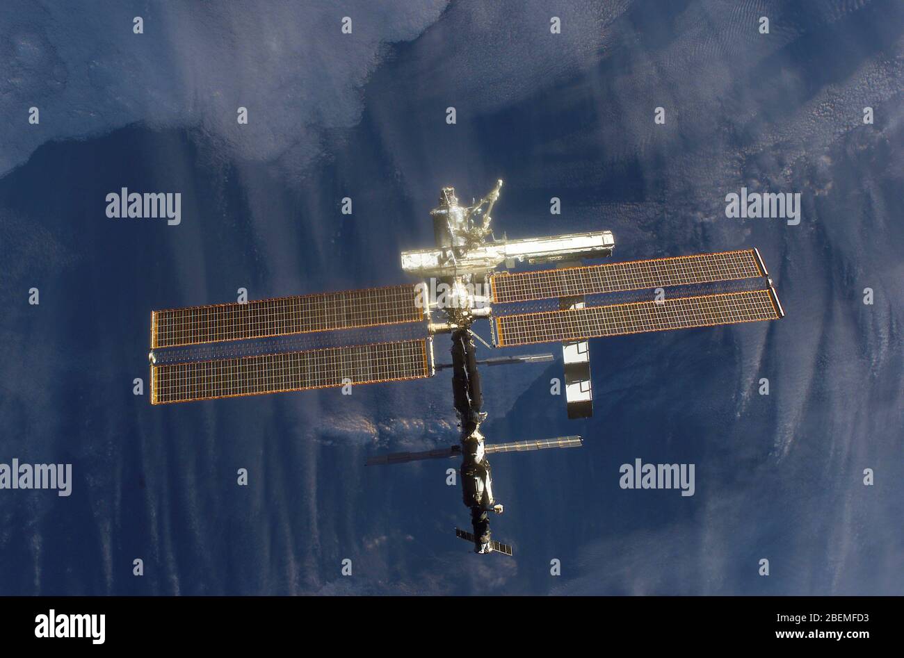 ISS - 16 October 2002 - Backdropped by a dark blue and white Earth, this full view of the International Space Station (ISS) was photographed by a crew Stock Photo