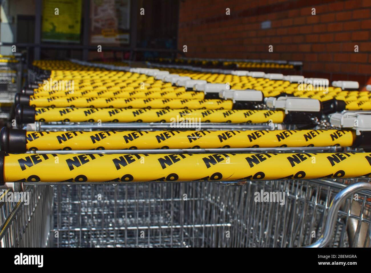 Berlin, Germany - April 02, 2018: A row of shopping trolleys with focus on the handles in the foreground. Stock Photo