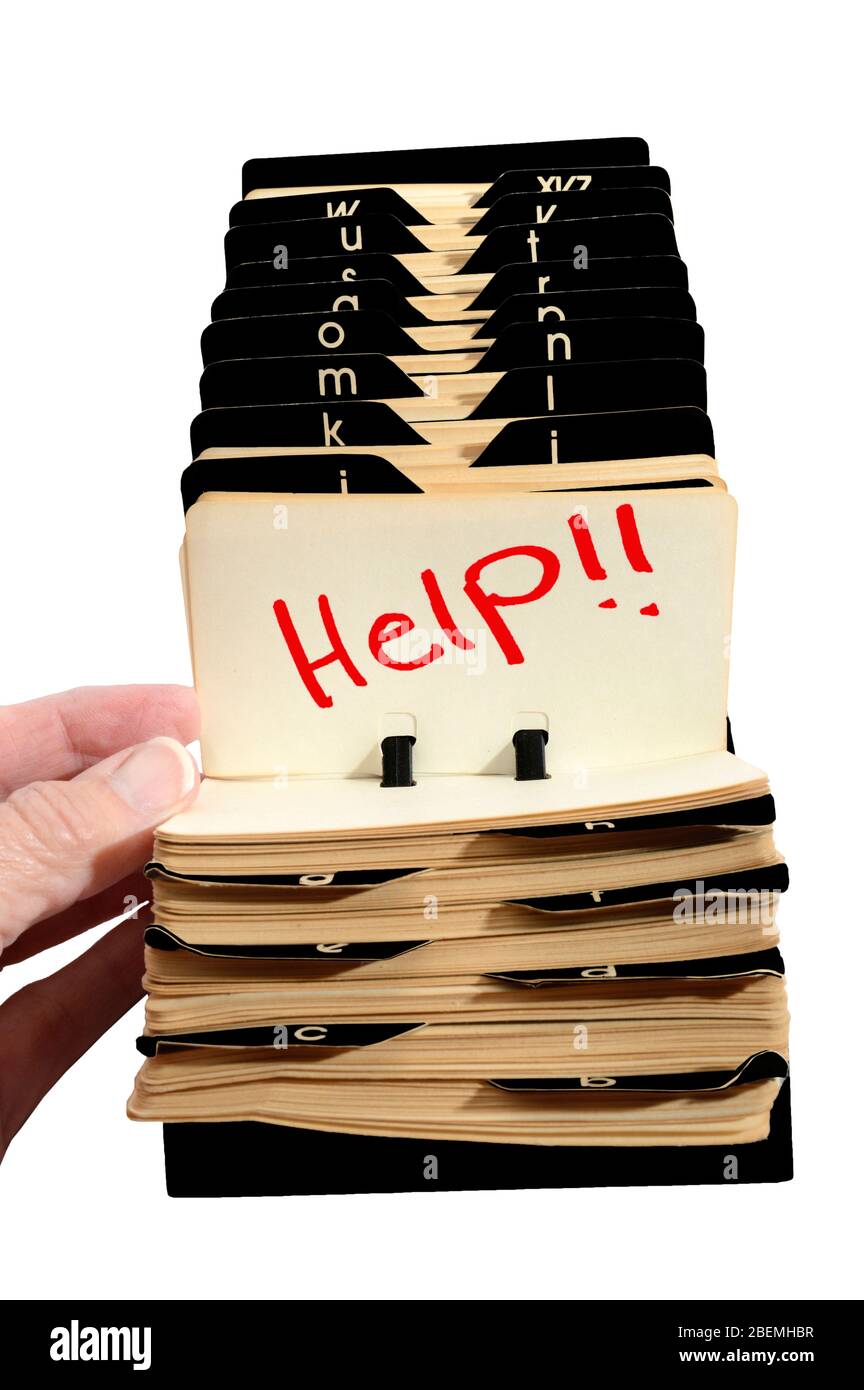 Vertical shot of an old Rolodex with a lady’s hand opening it to Help!! in red.  White background. Stock Photo