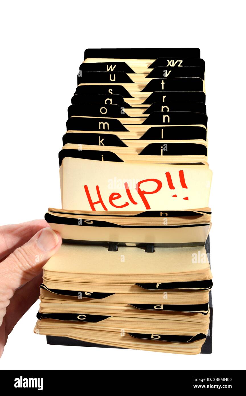 Vertical shot of an old Rolodex with a lady’s hand opening it to Help!! in red.  White background. Stock Photo