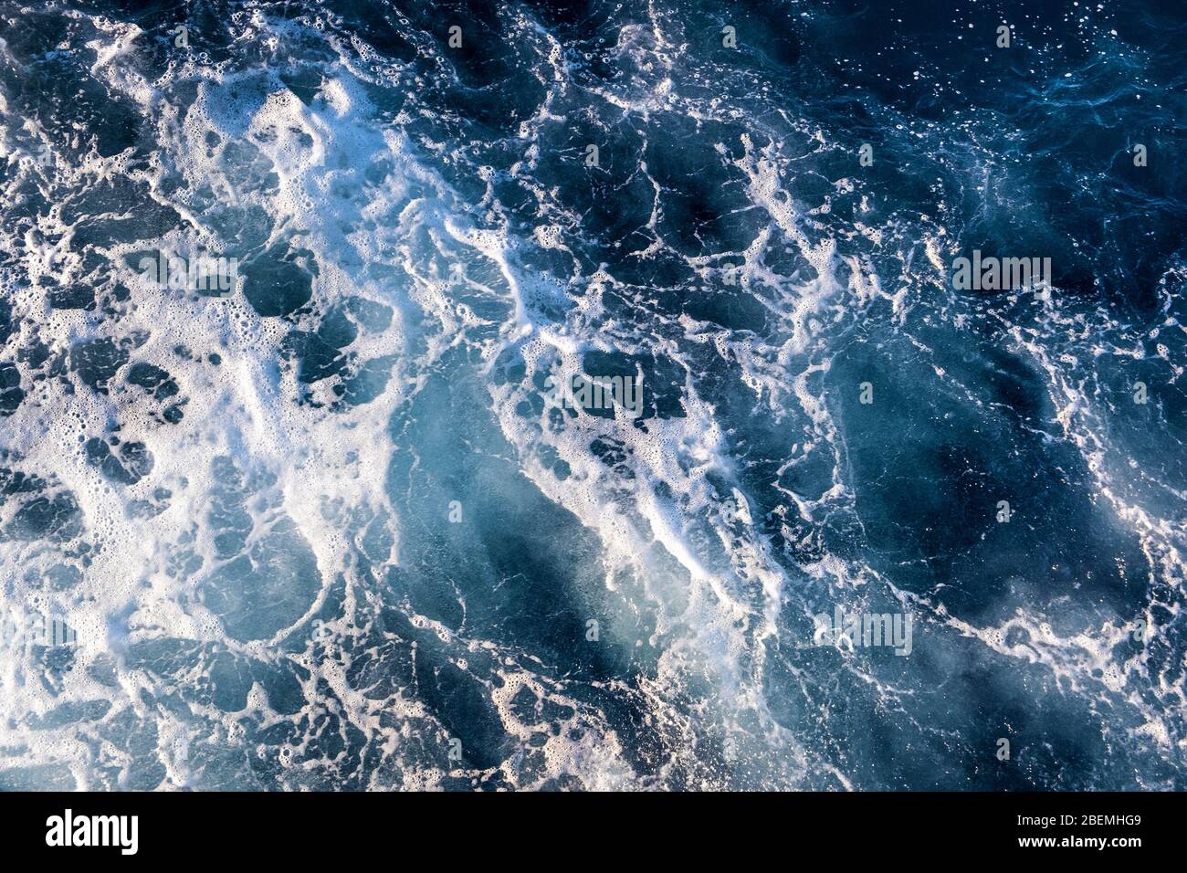 Top down aerial view of sea water surface. White foam waves texture as