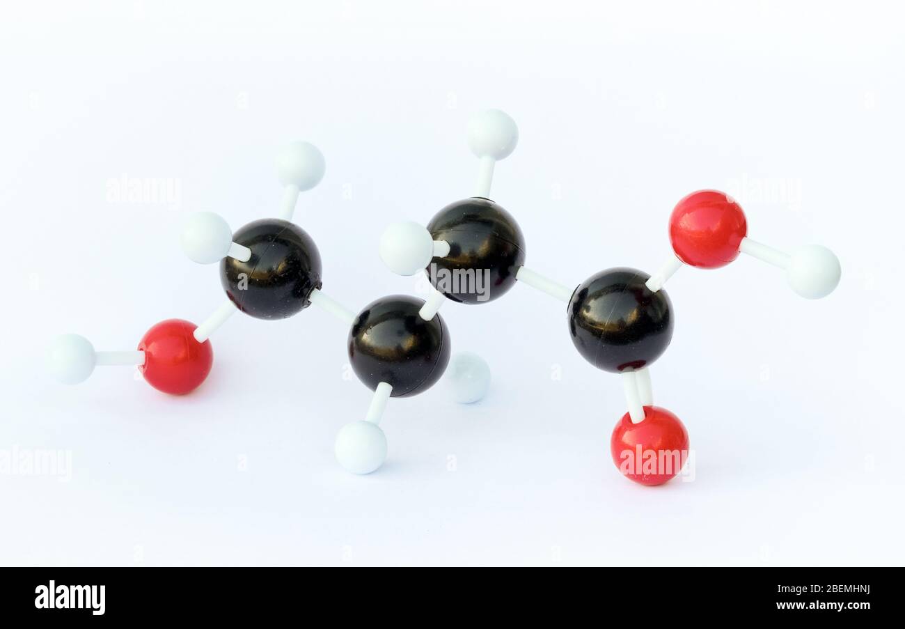 Plastic ball-and-stick model of a gamma-Hydroxybutyric acid (GHB) molecule against a white background. Stock Photo