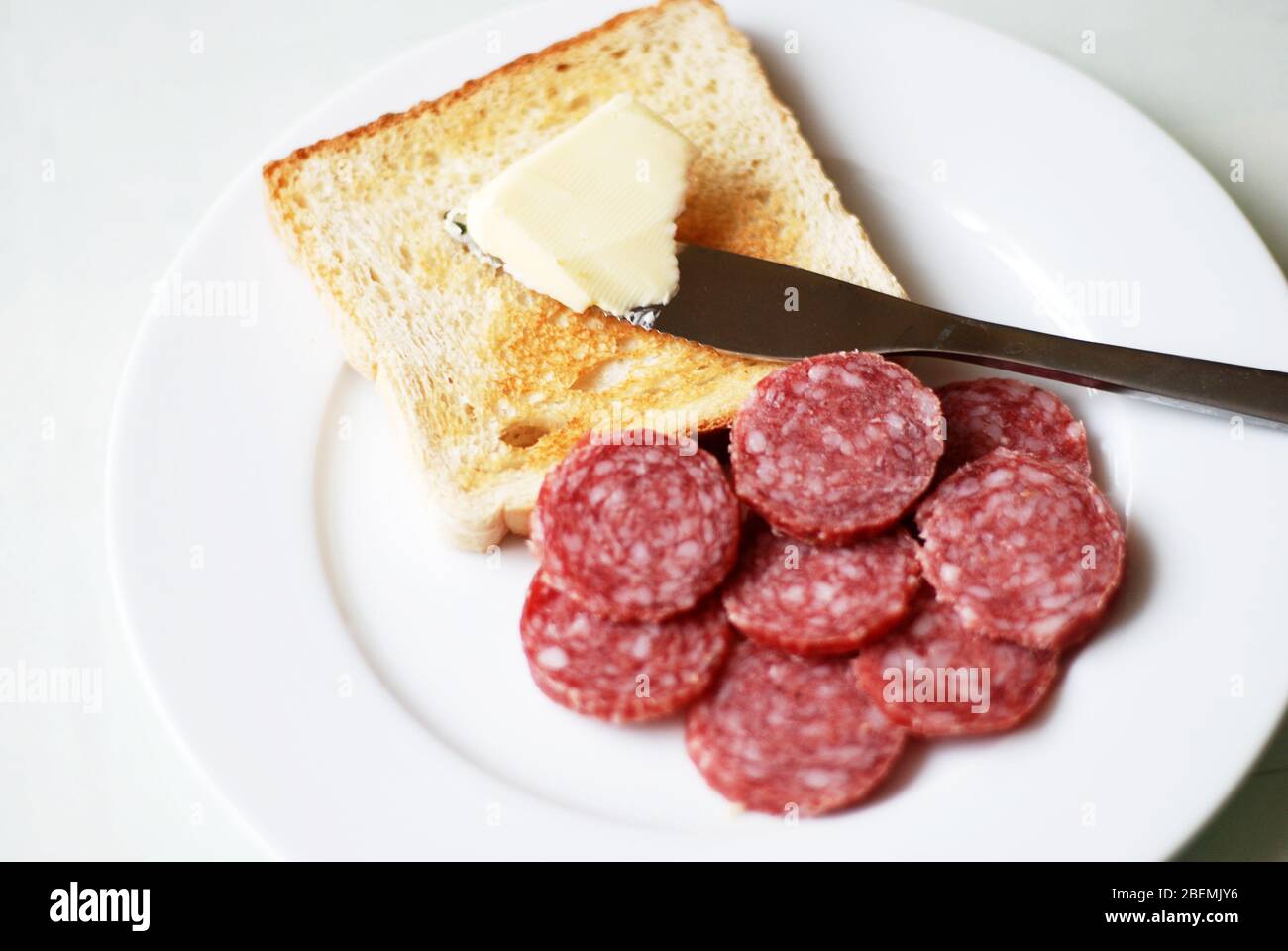 Butter toast with salami slices on a white plate Stock Photo - Alamy