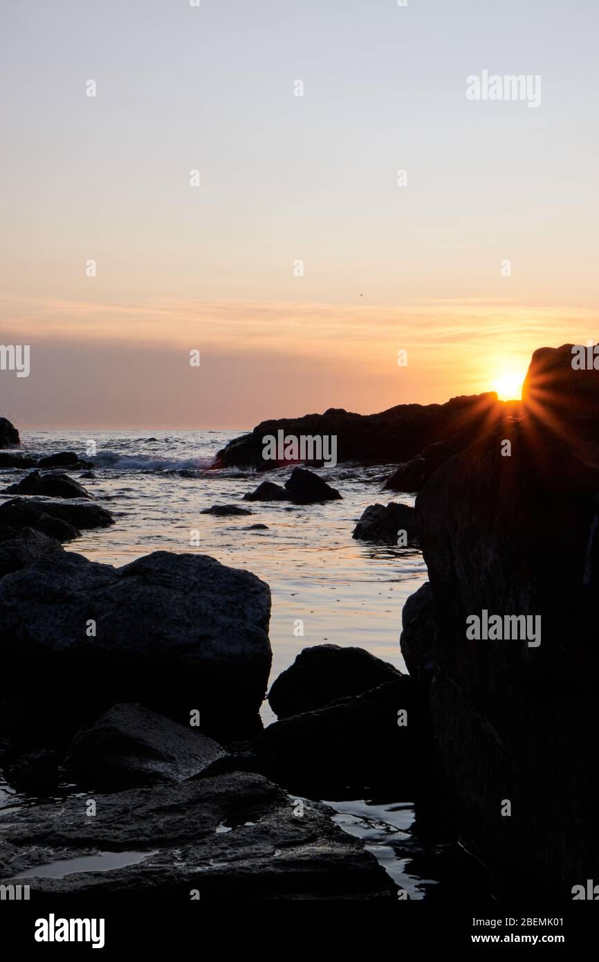 panoramic shot silhouette of sea stack rock formations at a golden ...