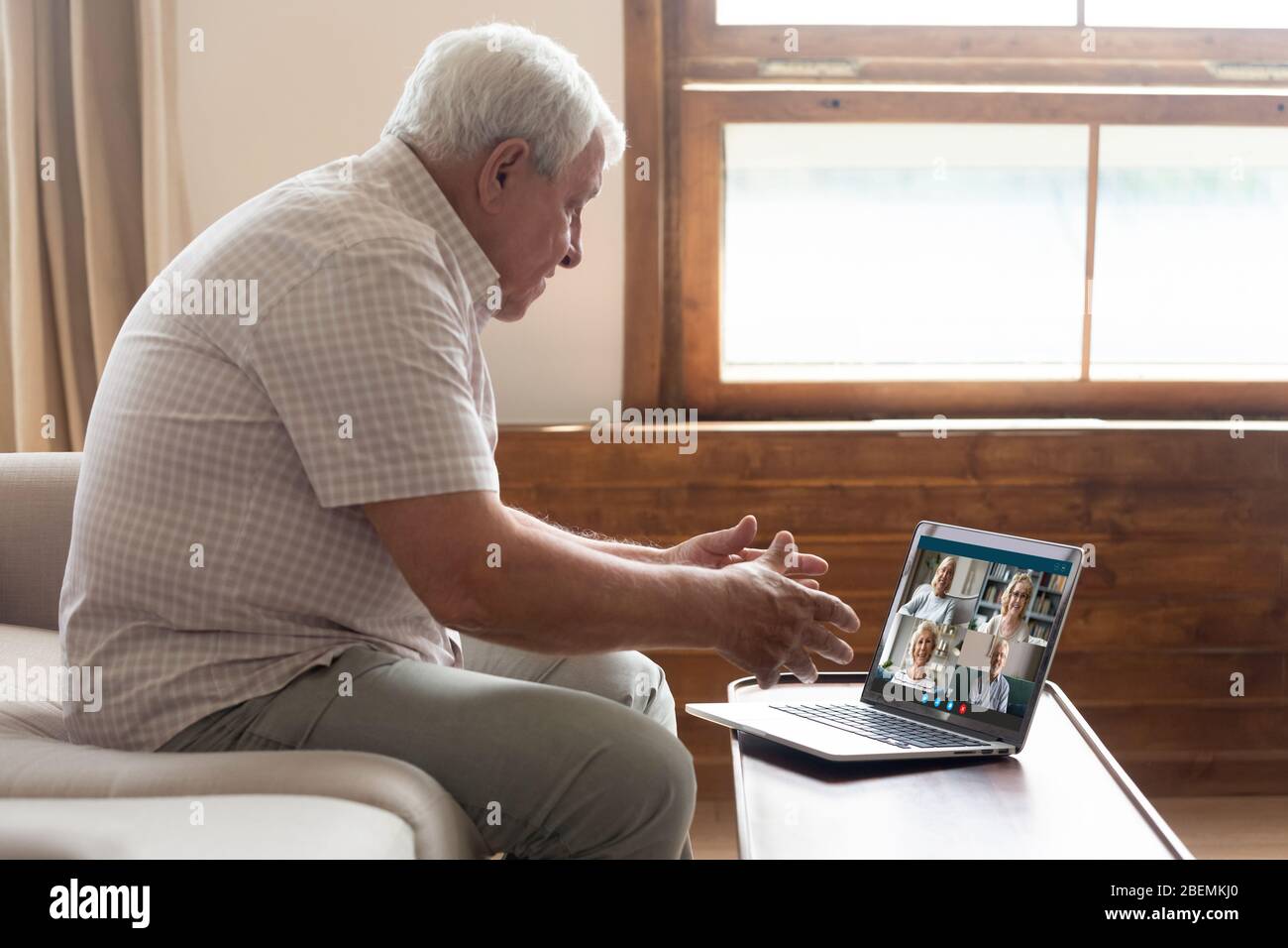 Grandfather talking with friends using pc webcam and videoconference app Stock Photo