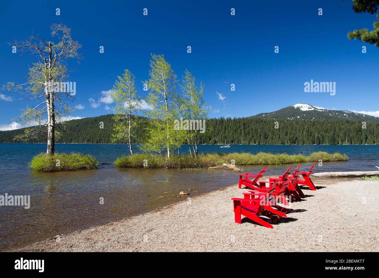 Red Adirondack chairs along the lakeshore of Lake of the Woods in the Fremont-Winema National Forest in southern Oregon Stock Photo