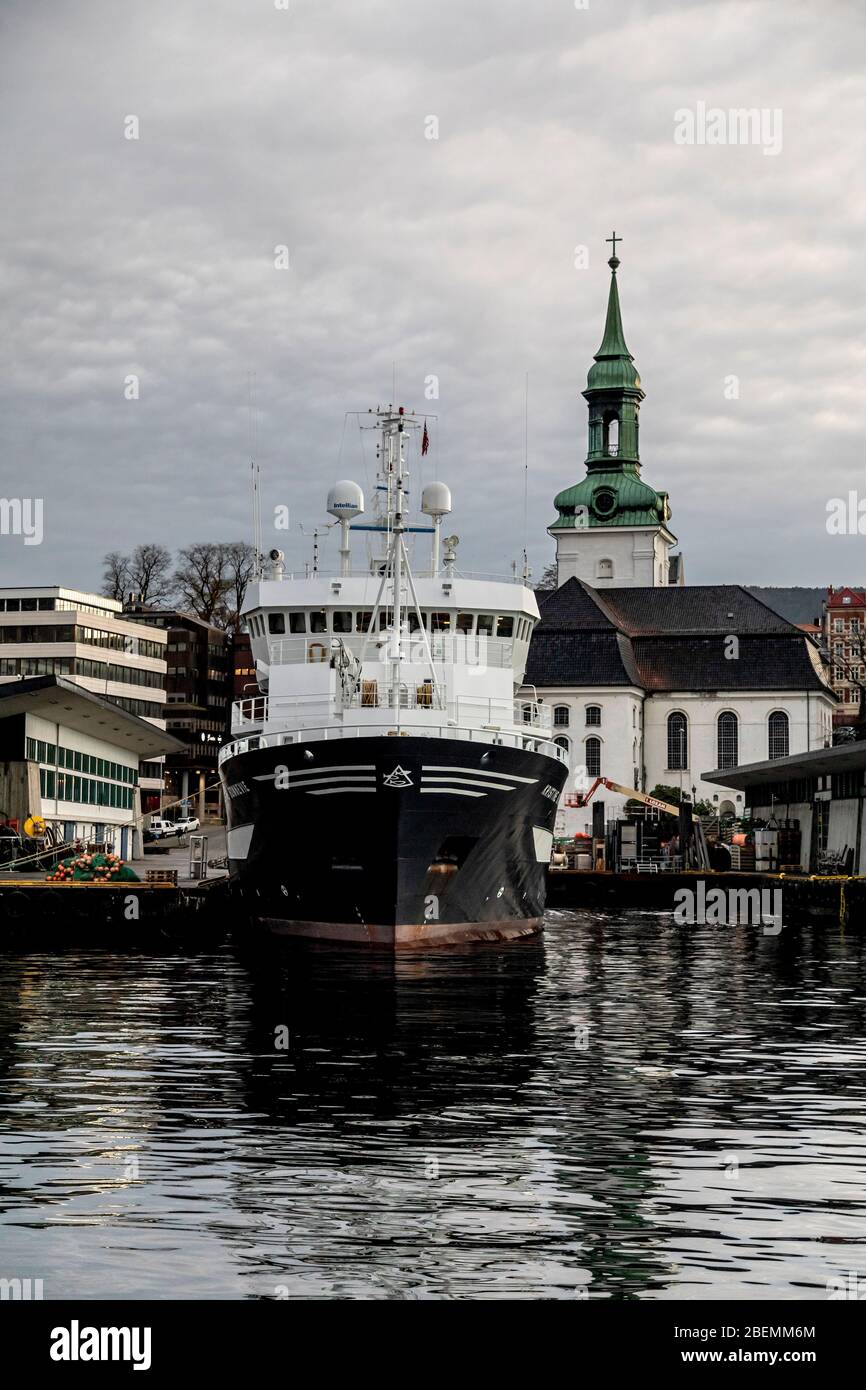 Ocean research vessel Kristine Bonnevie in the port of Bergen, Norway. Owned by the University of Bergen, Institute of Marine Research. Nykirken churc Stock Photo