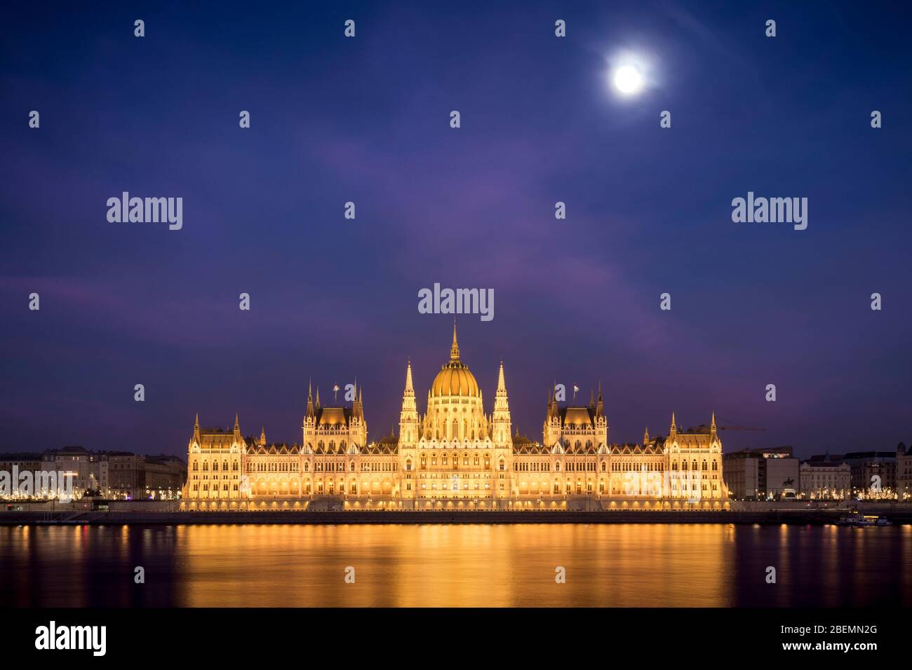 Moonrise over the Hungarian Parliament Building at night as seen from opposite bank of the Danube, Budapest Stock Photo