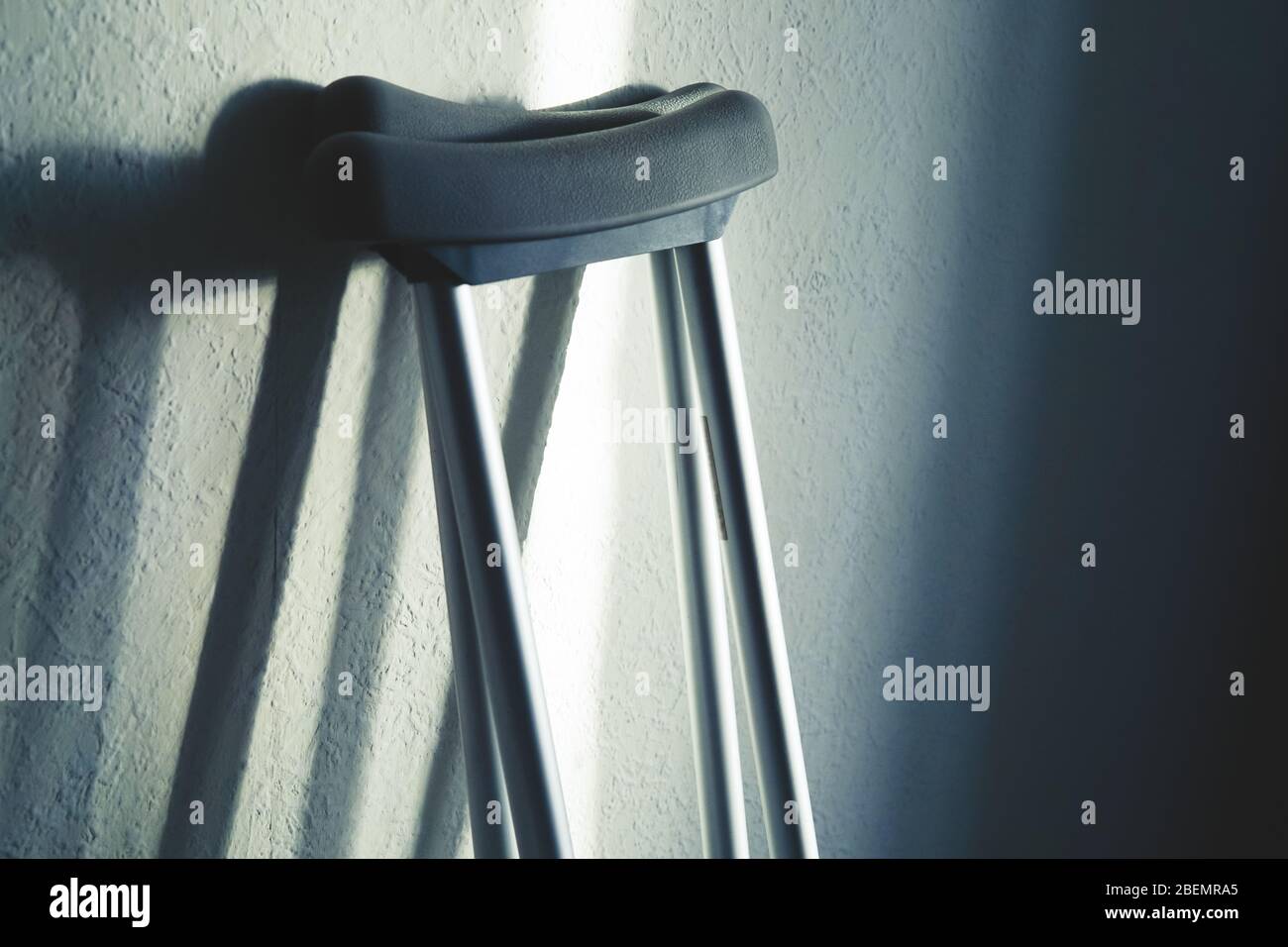 Close up image of crutches are standing against the wall. Place for text. Stock Photo