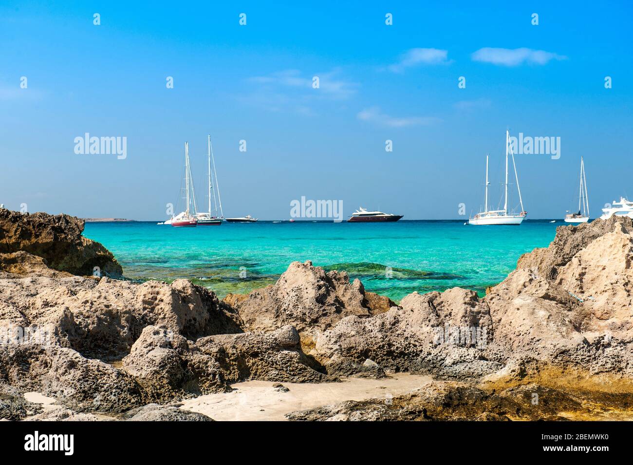 Ses Illetes beach, Formentera, Balearic Islands, Spain. The dreamy quiet of Ses Illetes beach with the dreamy sea with blue shades and sailing boats. Stock Photo