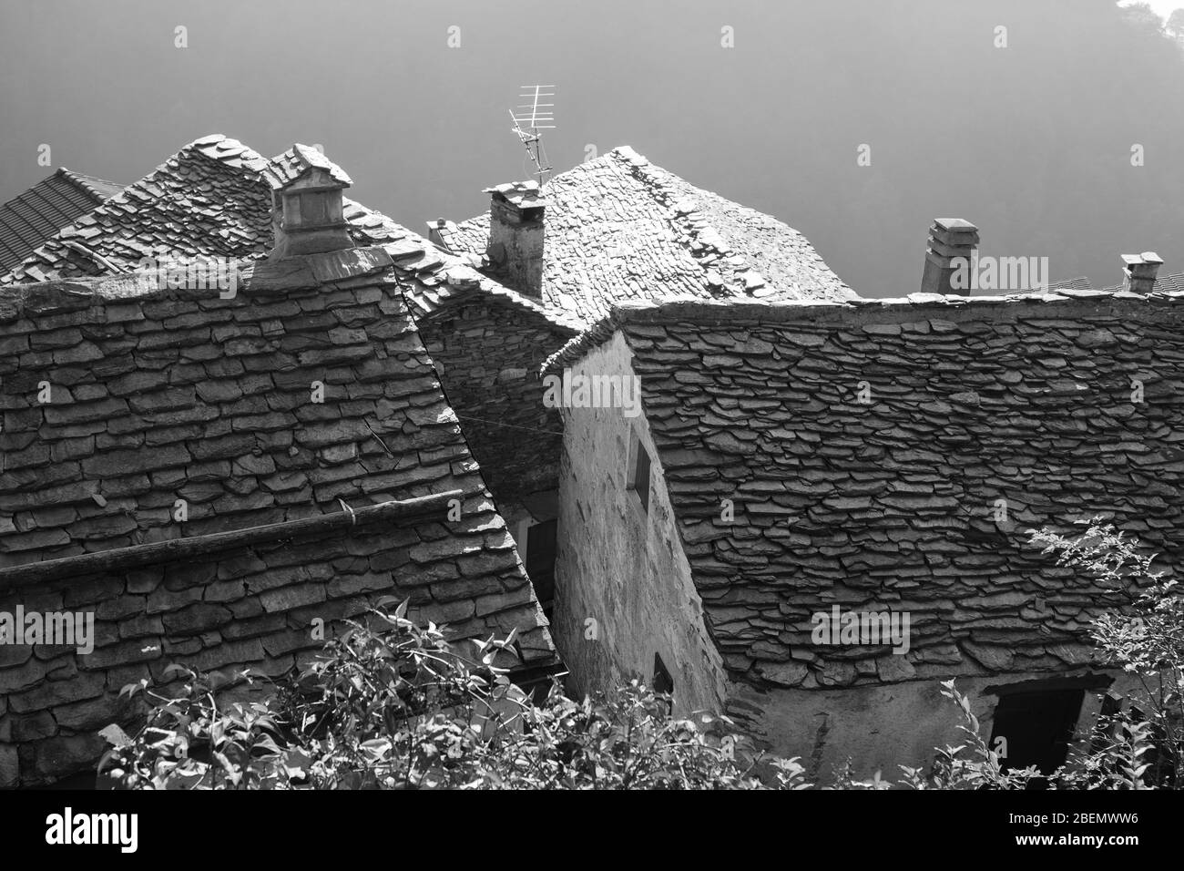old alpine village built on top of a mountain. Bell towers,Houses and stone roofs Stock Photo