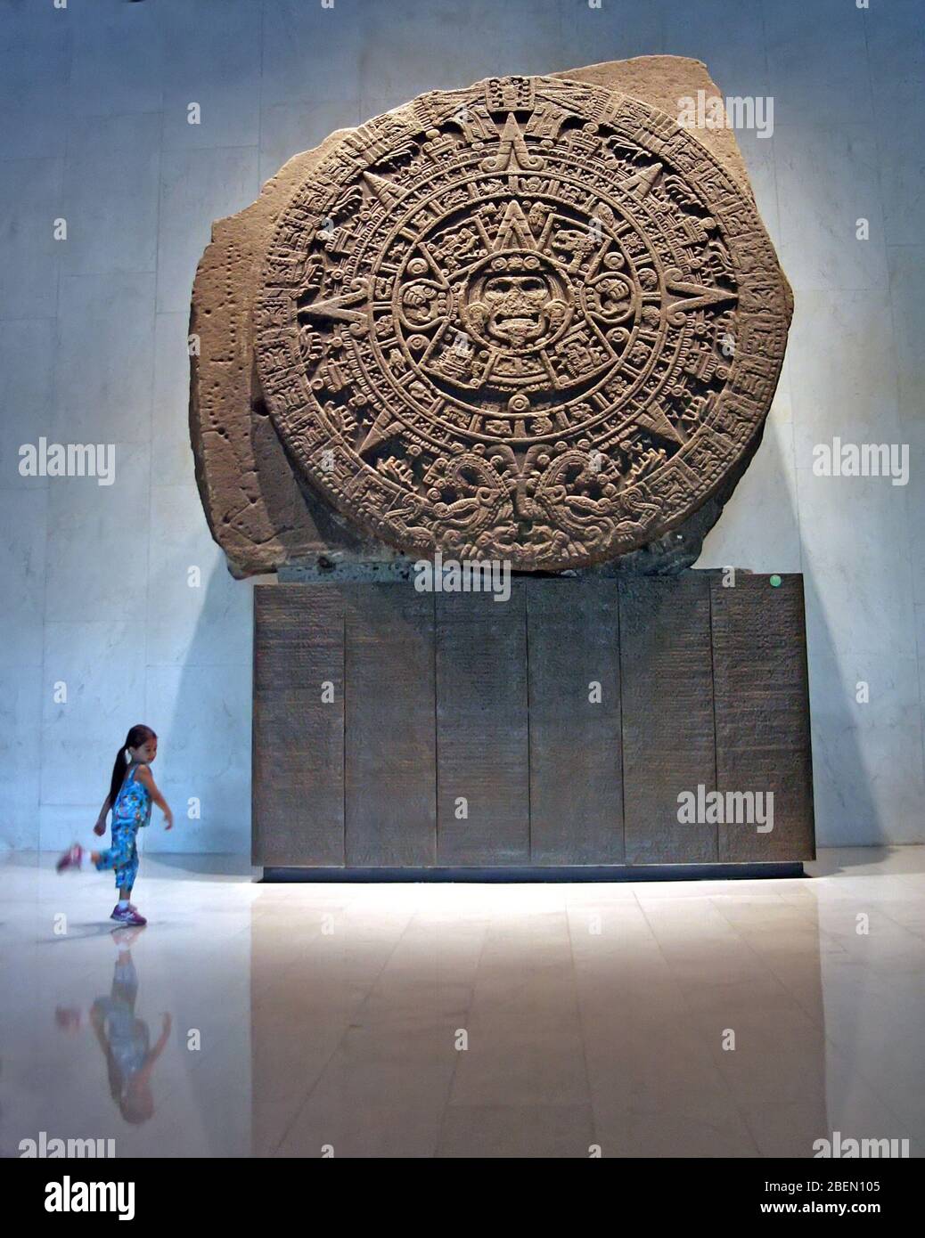 Young girl dances in front of the Sun Stone in Anthropology Museum, Mexico City, Mexico Stock Photo