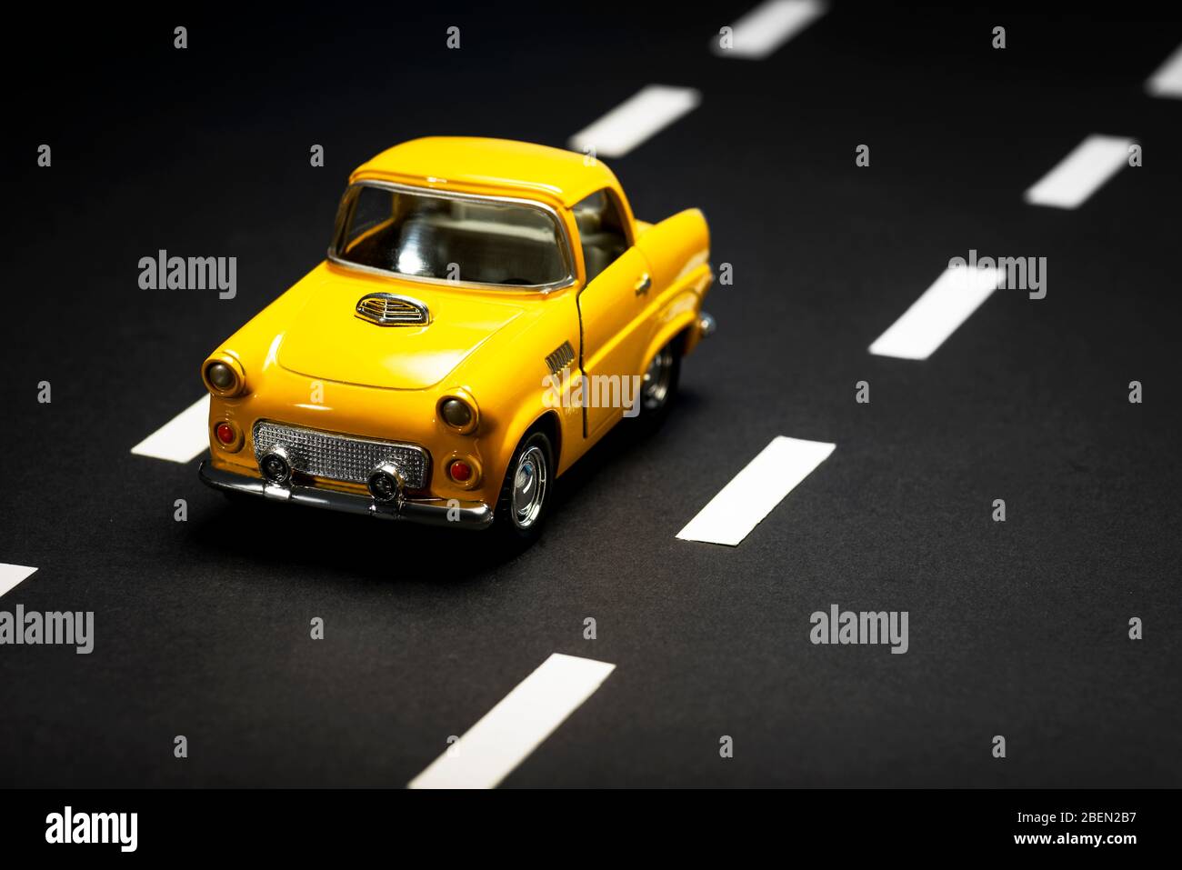 Front view of a Yellow toy car on on an asphalt road Stock Photo - Alamy