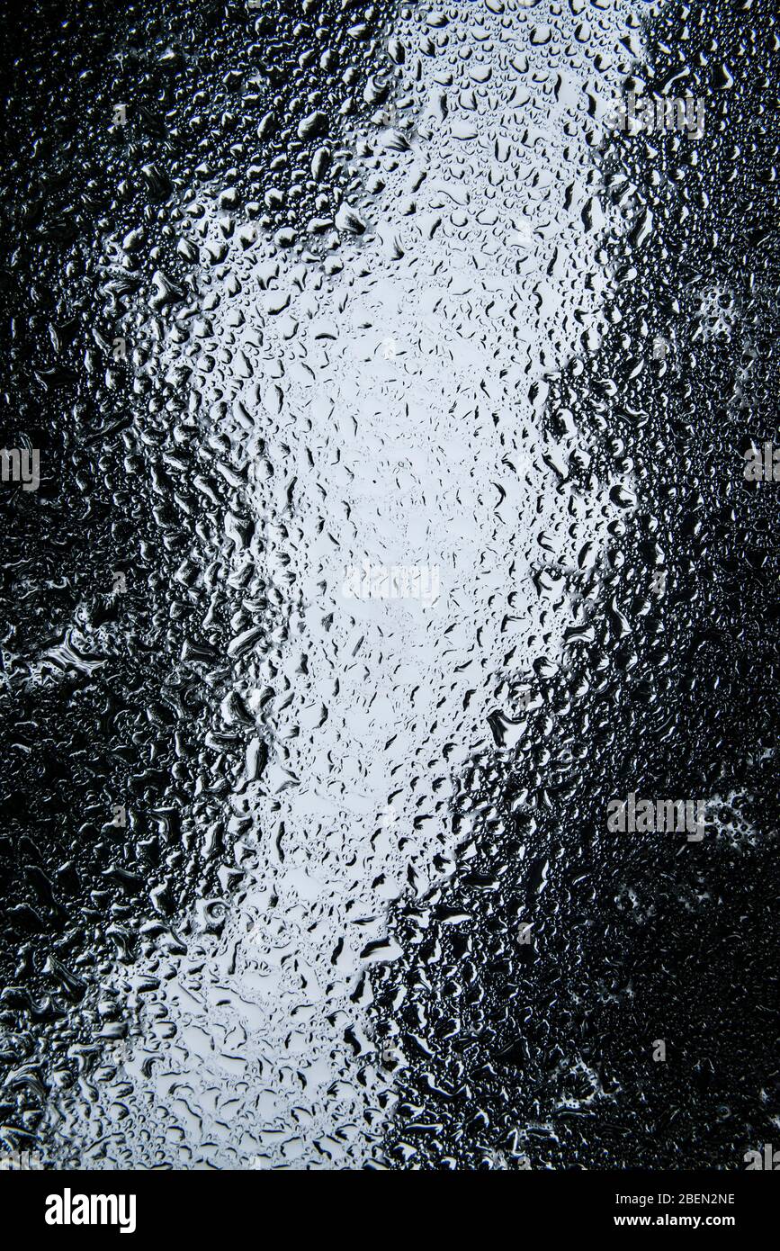 Raindrops Pooling on a Windshield in Forest Scene Stock Photo