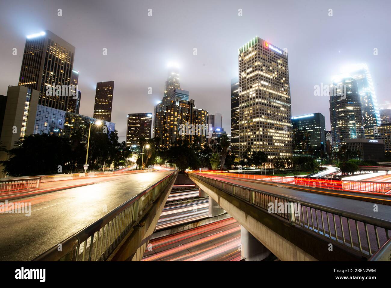 Car Streak By Bridges and Freeway on Foggy Night in Downtown LA Stock Photo