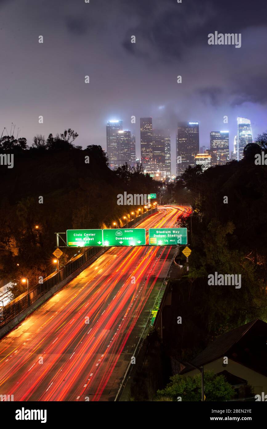 Car Streak By Bridges and Freeway on Foggy Night in Downtown LA Stock Photo