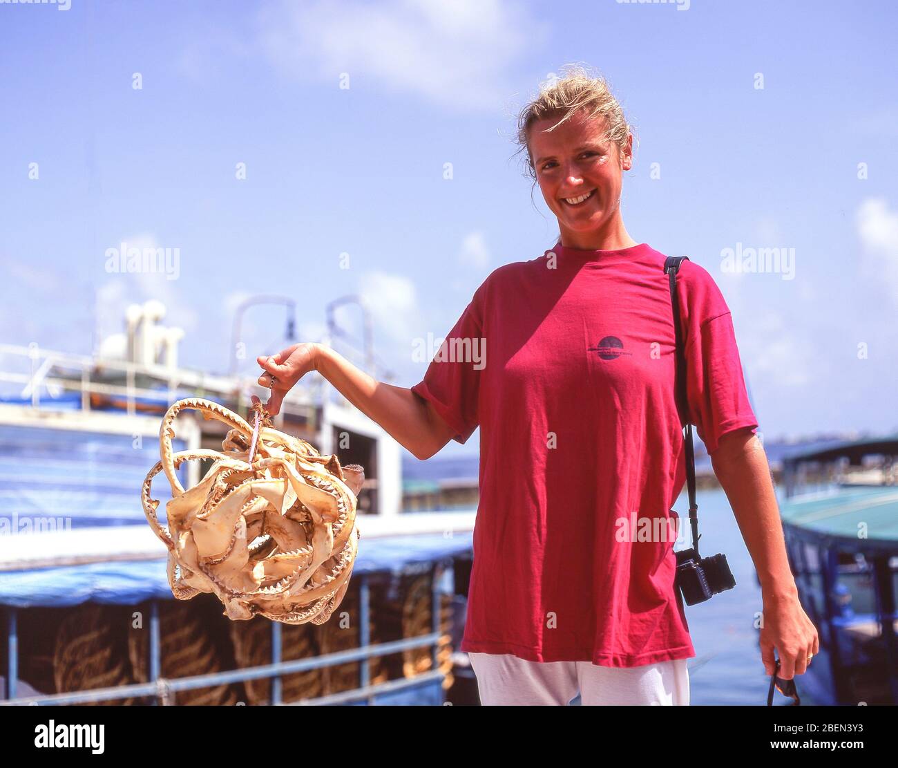 Young woman holding a bunch of shark's teeth, Male, Kaafu Atoll, Republic of Maldives Stock Photo