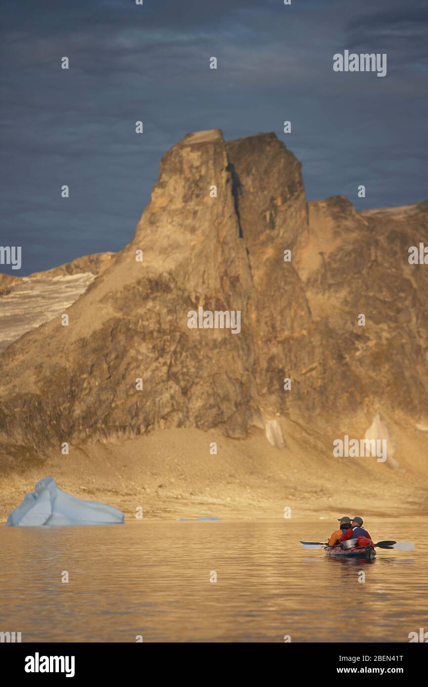 2 men traveling with a sea kayak in Eastern Greenland Stock Photo