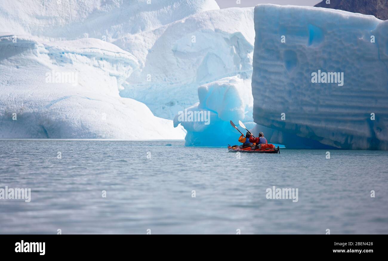 2 men traveling with a sea kayak in Eastern Greenland Stock Photo