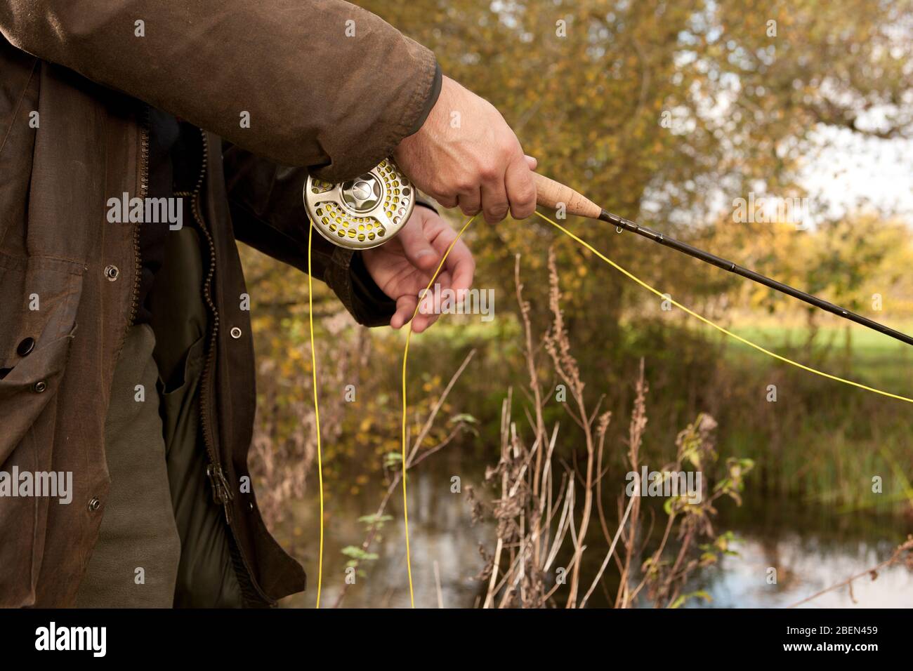 close up of man holding fly fishing reel in the UK Stock Photo