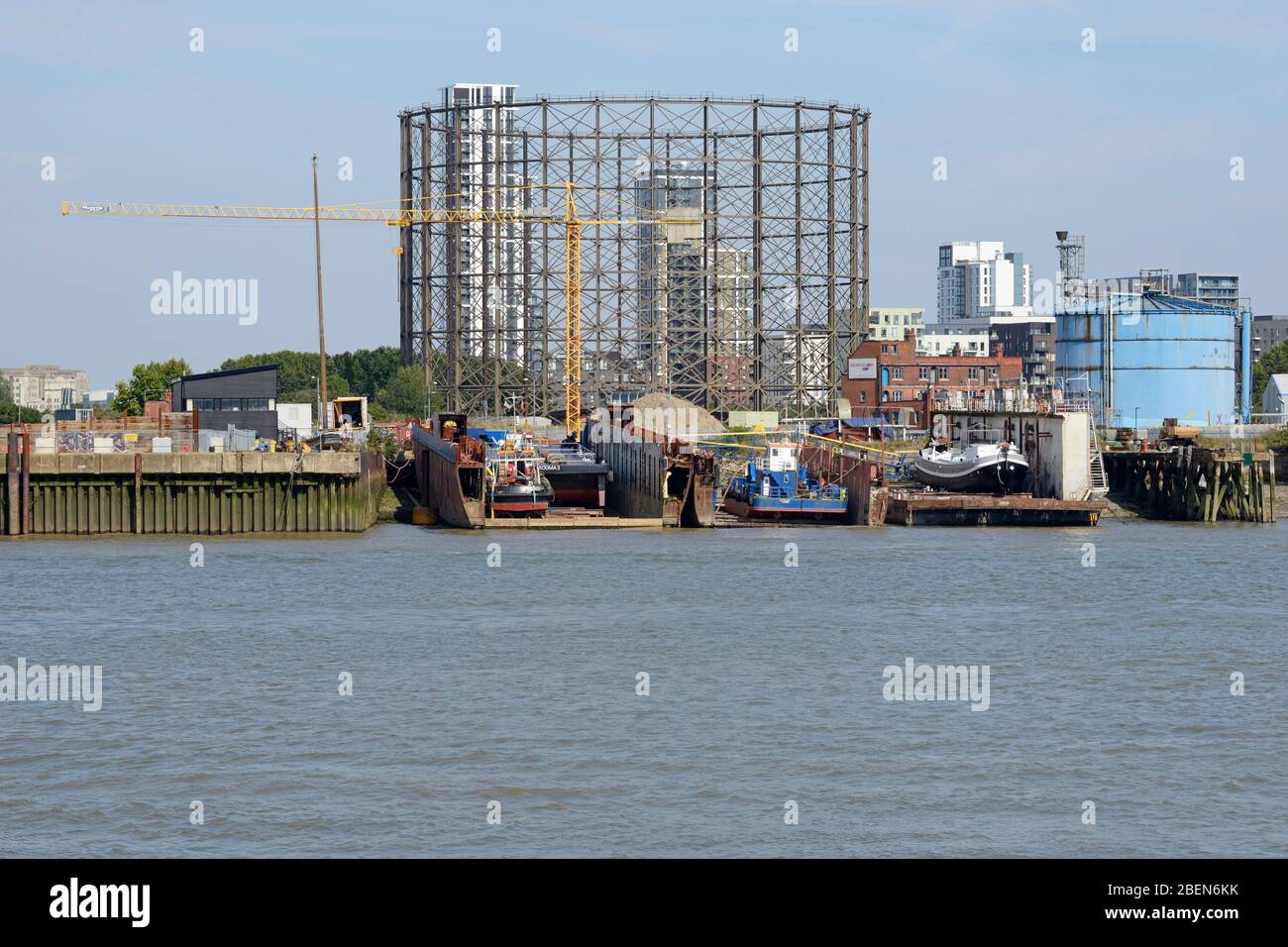 View across the river Thames to a boatyard on the western bank of the Greenwich peninsula. London, UK Stock Photo