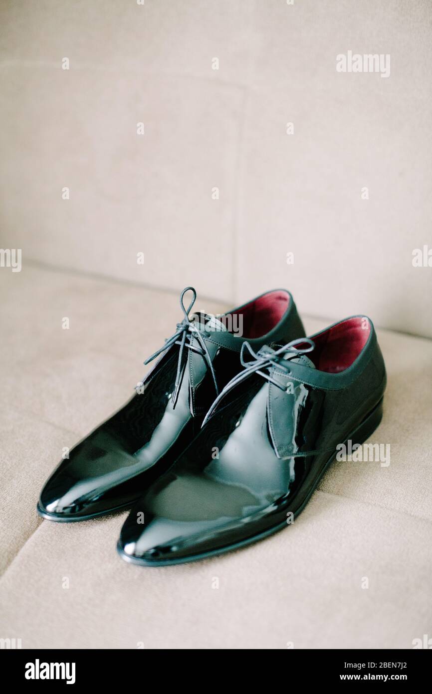 Black patent leather wedding shoes. Wedding reparations details. Indoor and close up. Stock Photo